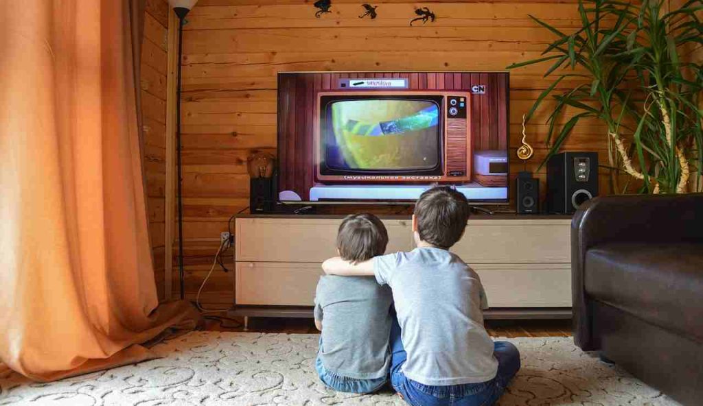 Due bambini mentre guardano la TV (Pixabay)