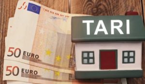 Modellino di casa con scritta Tari con accanto banconote euro