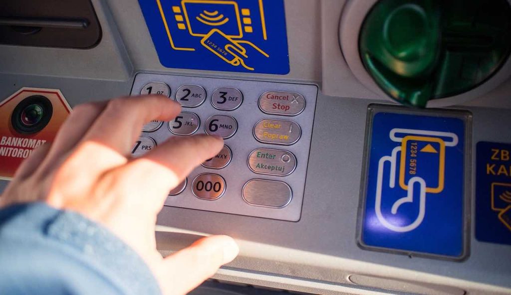 Donna digita il pin al Bancomat