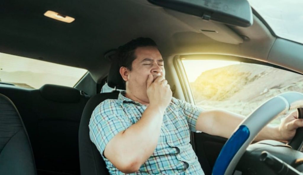 Uomo sbadiglia al volante