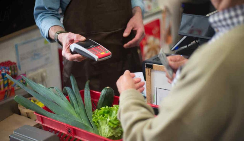 Persona che paga alla cassa del supermercato