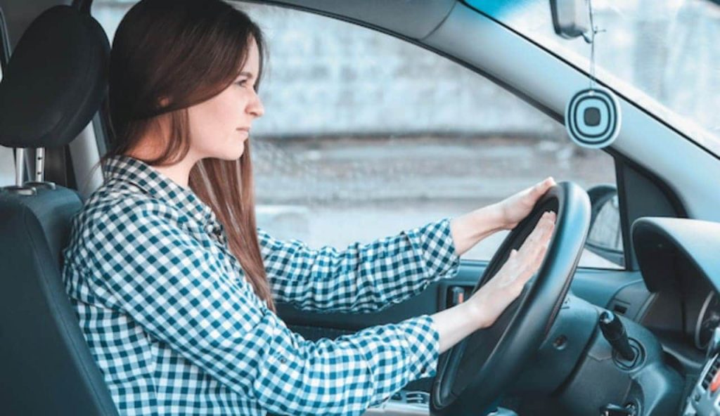 Donna giovane al volante di auto piuttosto nervosa