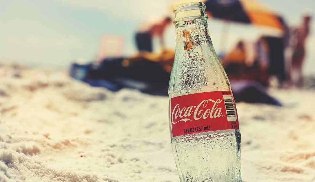 Bottiglia di Coca Cola vuota sulla spiaggia